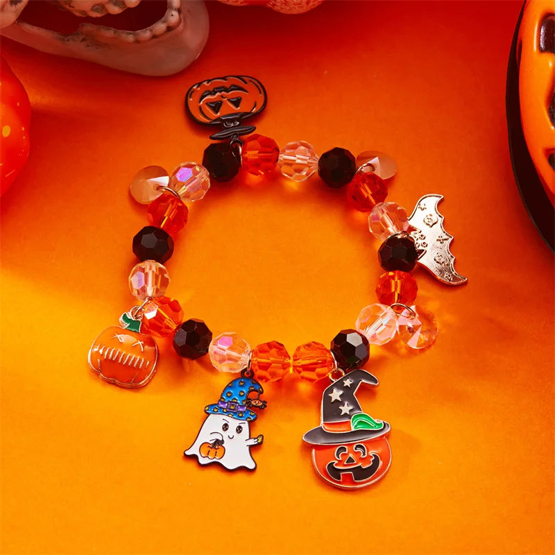 A bracelet made of amber and black beads featuring Halloween pumpkin and ghost charms.