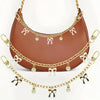 A brown leather bag with gold chain detailing and pink ribbon embellishments