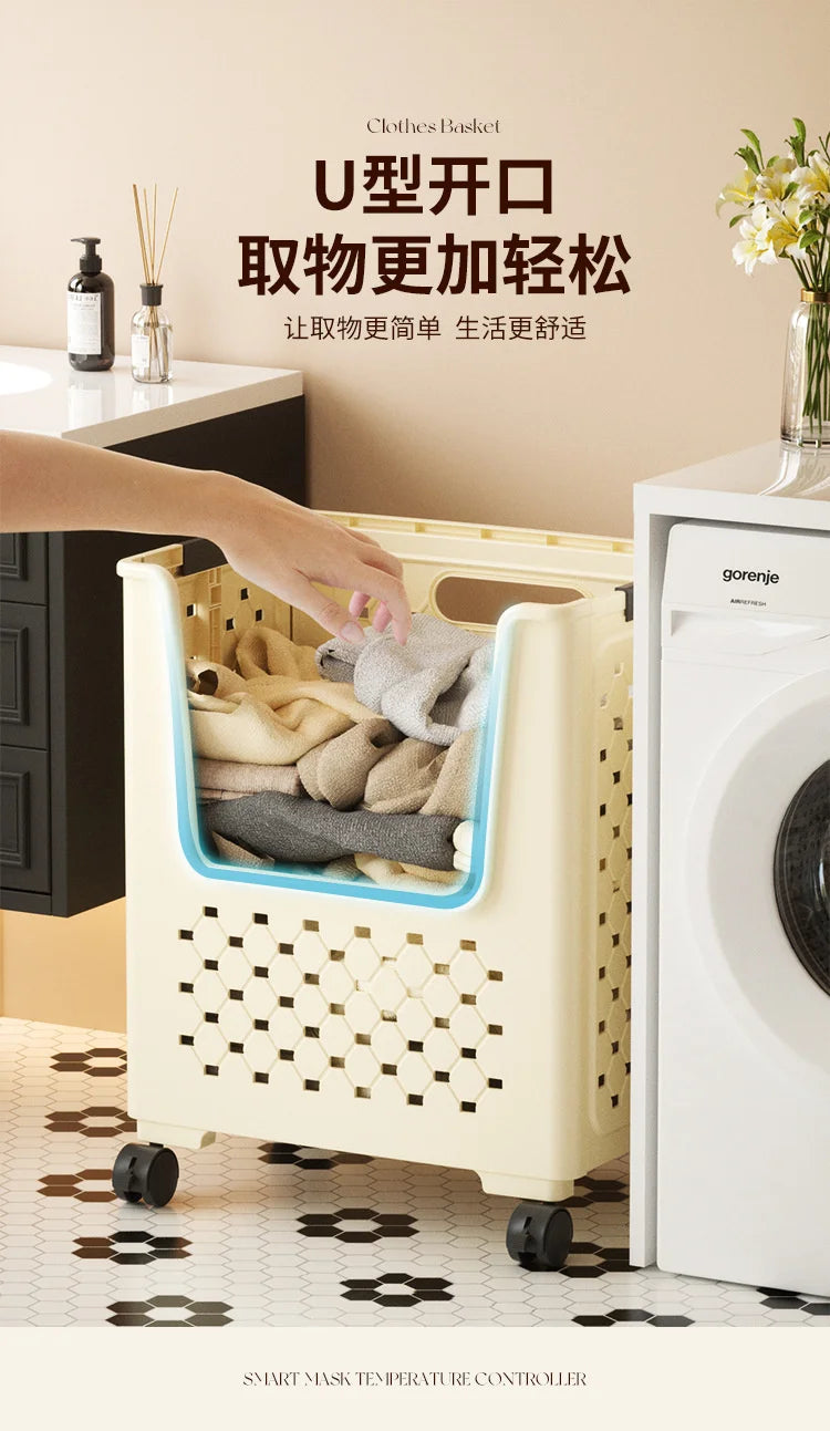 A person is placing folded laundry into a light-colored, square mesh basket with handles, next to a white washing machine.