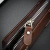 A close-up of a brown retro PU leather men's wallet with a visible zipper and leather strap.
