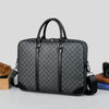 A black executive PU leather laptop briefcase with a shoulder strap is shown on a light gray surface.