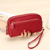 A red genuine cowhide leather double-zip wristlet wallet is shown being held by a hand.