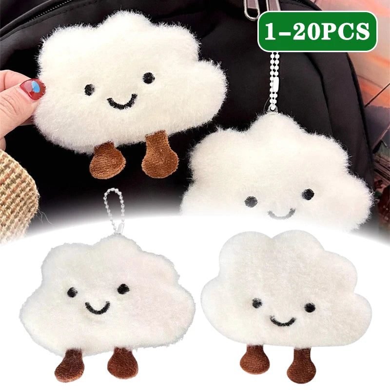 White fluffy cloud shaped plush keychains with brown feet and black embroidered faces