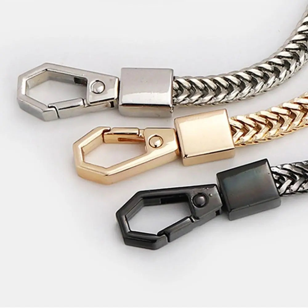 Three metal bag chain straps in silver, gold, and black finishes displayed against a white background.