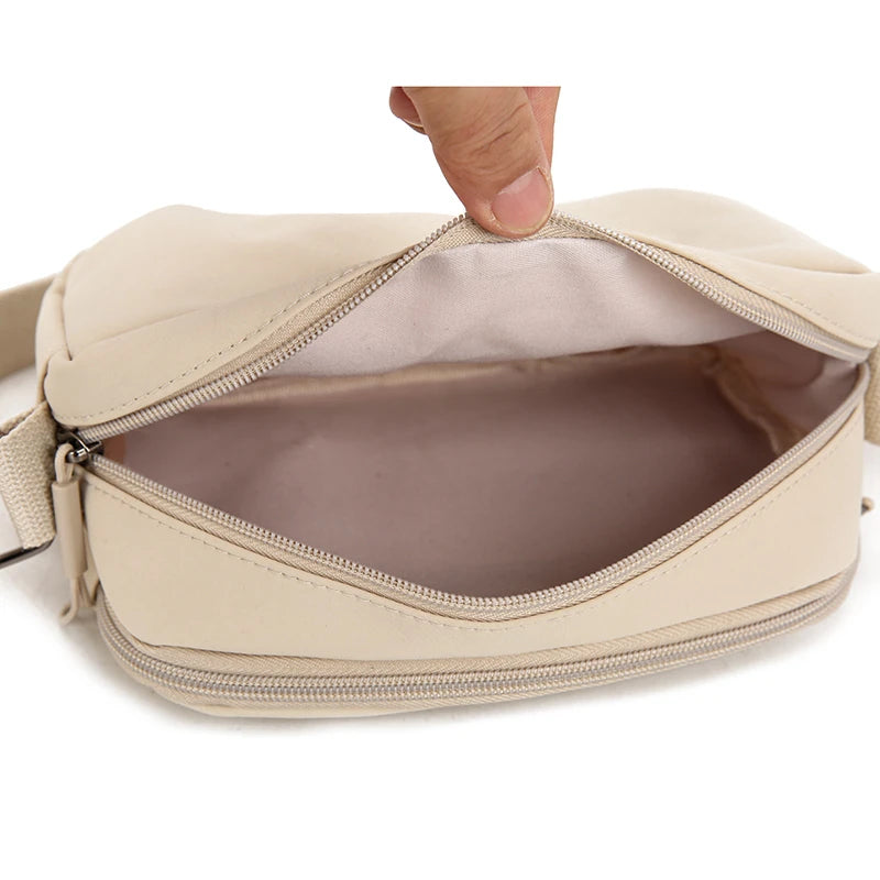 Bolso cruz impermeable de nylon beige abierto, mostrando el forro interior.