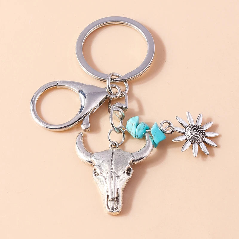 Silver gothic steampunk heart keychain featuring a sun eye pendant on a light beige background