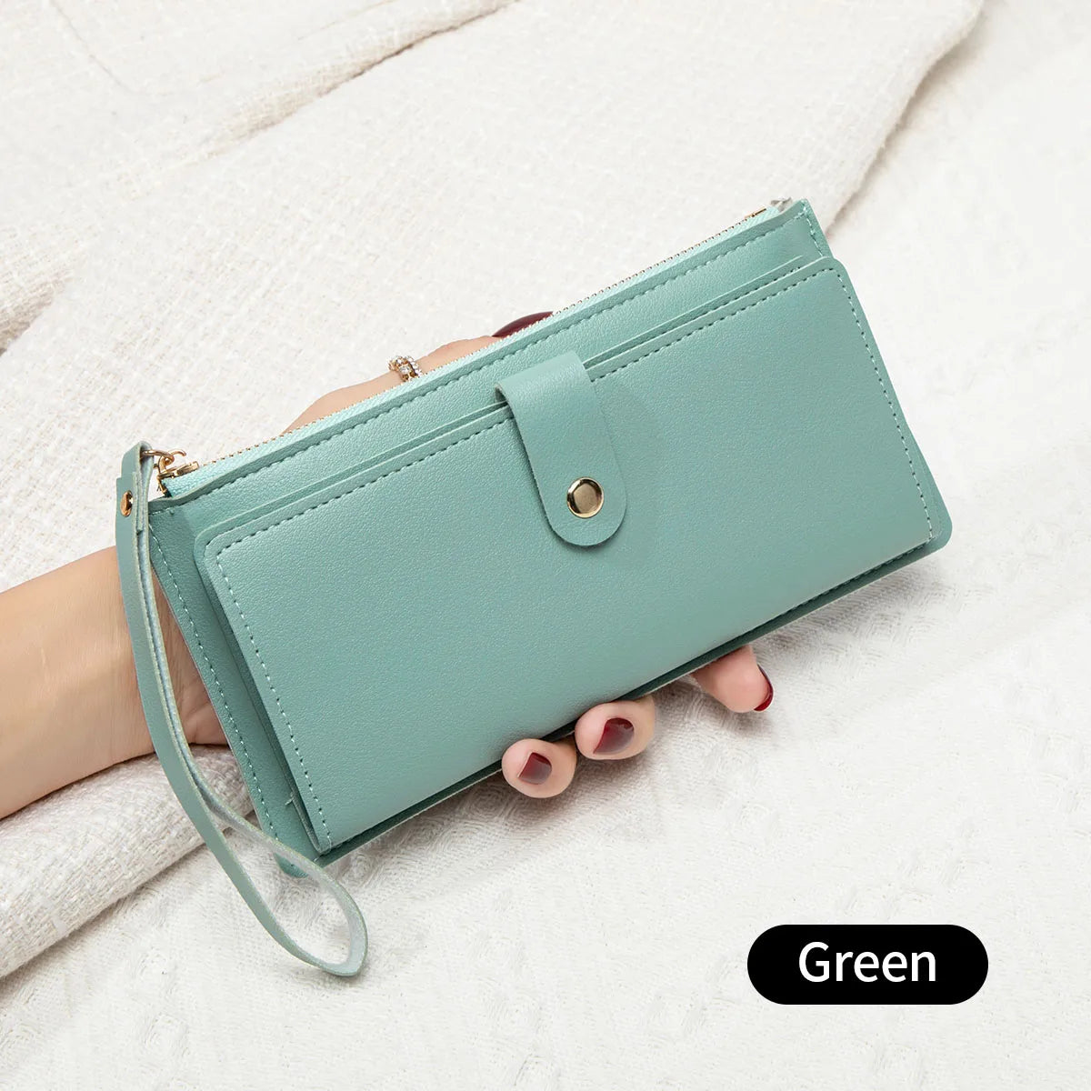 A mint green elegant PU leather coin purse and card holder is shown being held by a hand on a white surface.