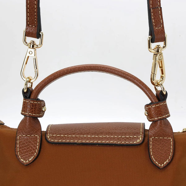 A brown leather shoulder strap kit with gold hardware and a rectangular leather flap for mini bags.