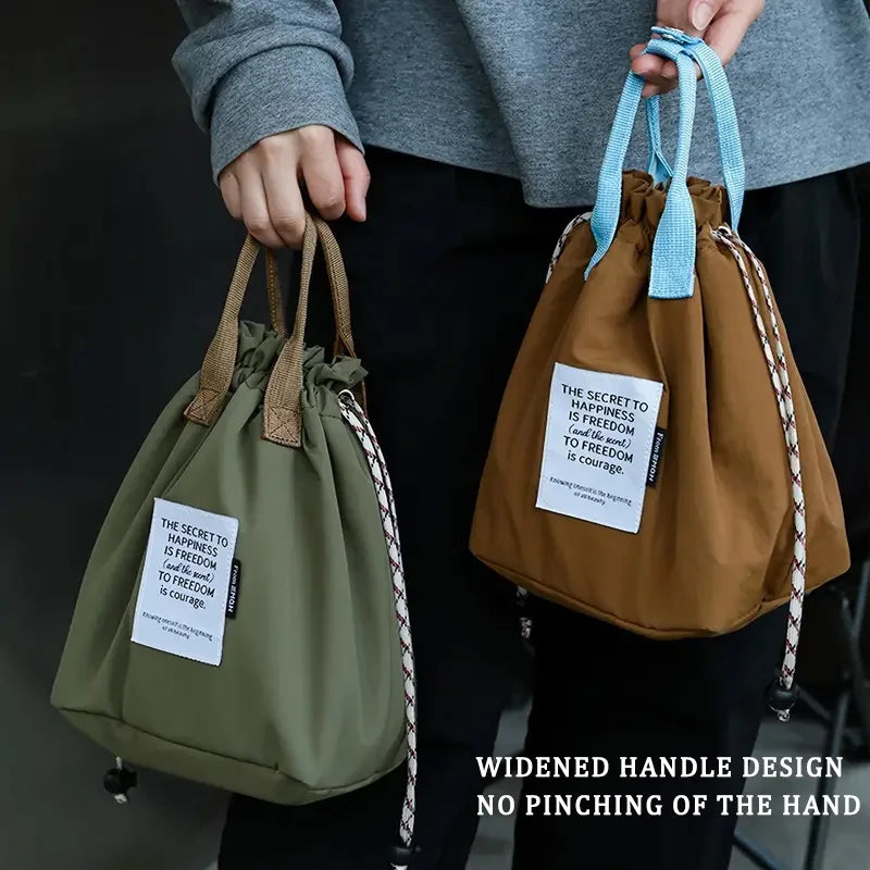 A person holds a brown waterproof insulated lunch bag with a light blue drawstring and a green one.