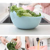 A light blue plastic basket used for multi-purpose storage, holding fresh green lettuce leaves.