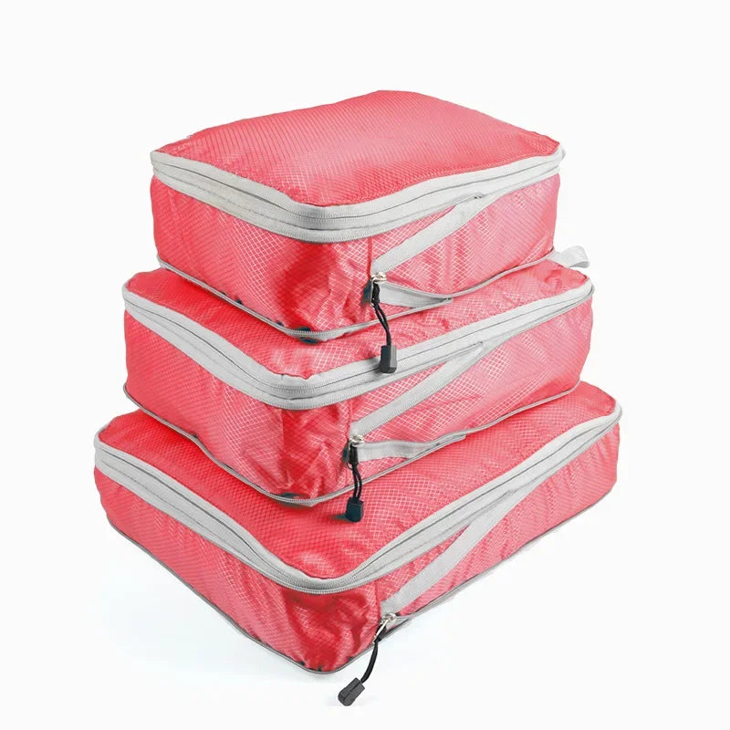 A set of three red and gray reusable compression packing cubes.