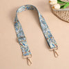 A beige adjustable bohemian printed crossbody strap with blue and white patterns is displayed on a light background.