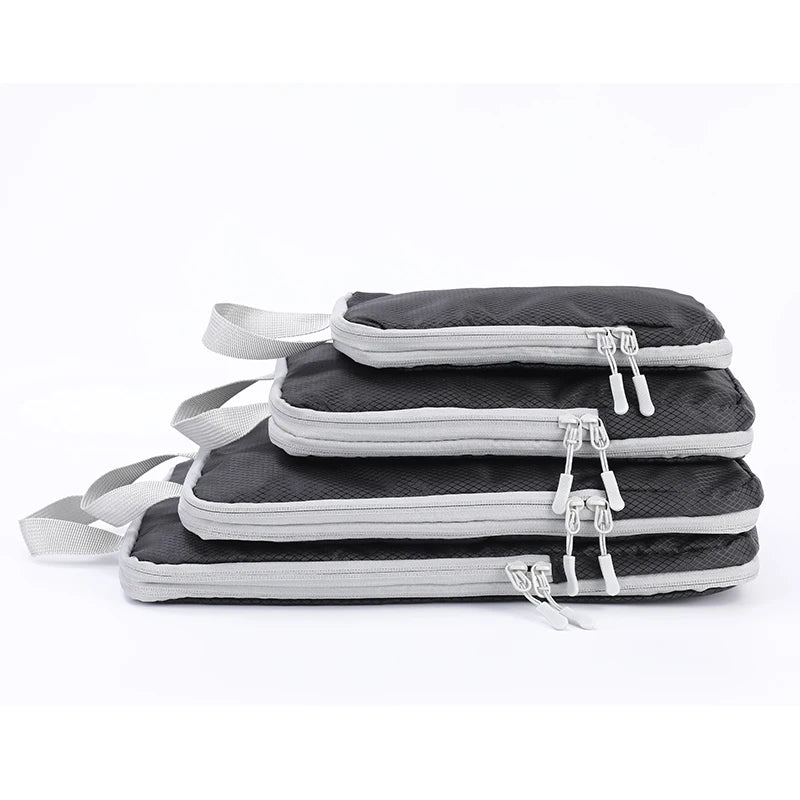 A set of four vertical travel organizer bags in black and gray fabric with adjustable straps.