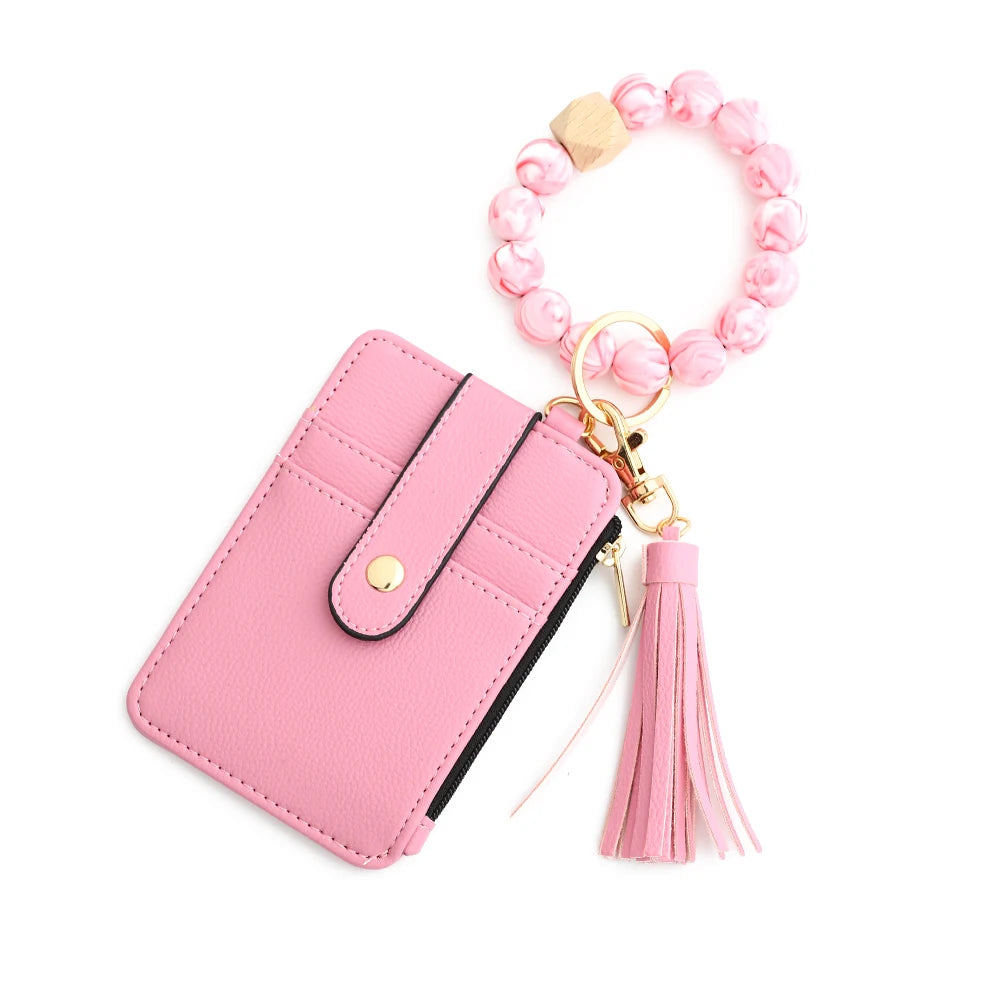 Pink leather card holder with a gold chain and pink beaded bangle keychain