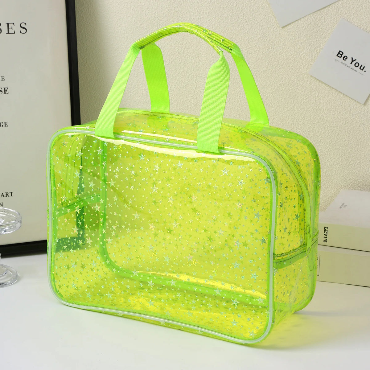 A clear, lime green waterproof makeup organizer bag with a handle is displayed on a white surface.