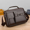 A dark brown men's PU leather crossbody shoulder bag with a flap and strap resting on a wooden surface.