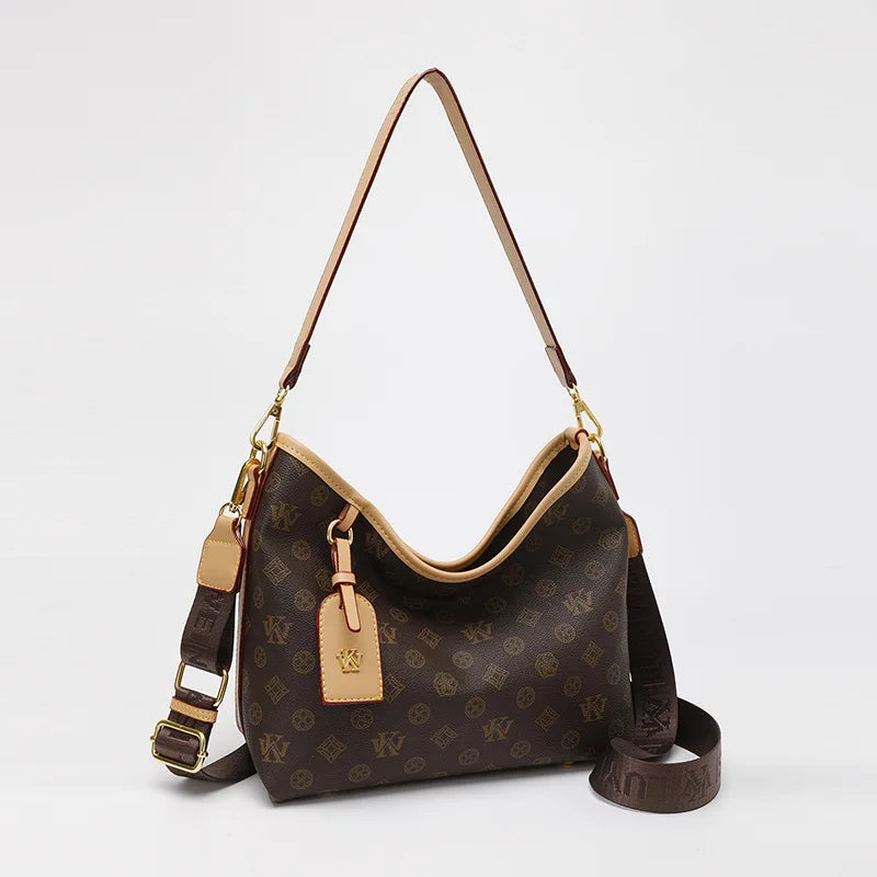 A brown leather crossbody tote bag with a monogram pattern and gold hardware.