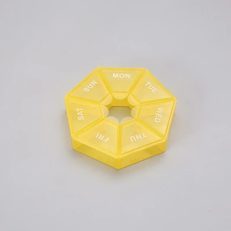 A yellow, hexagonal pill organizer divided into seven sections labeled with the days of the week.