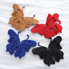 Four decorative butterfly appliqués in brown, red, blue, and black fabric.