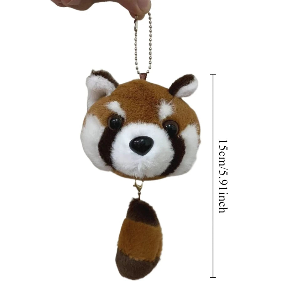 A plush toy of a red panda with brown and white fur, hanging from a chain.