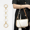 A white moon-shaped bag chain strap with a gold alloy clasp is shown against a black garment.