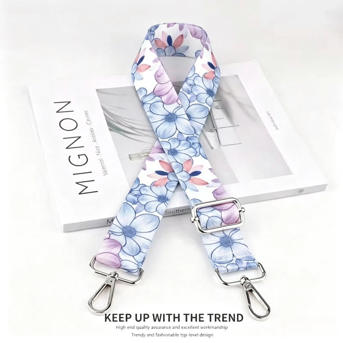 A floral patterned nylon crossbody bag strap with a silver metal buckle displayed on a white box.