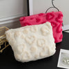 A white plush heart-pattern storage bag next to a pink plush heart-pattern storage bag.