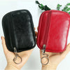 A hand holds a compact black and red PU leather mini wallet with a silver keychain.