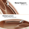 Close-up view of a tan felt insert bag for a handbag, showing metal zippers and multiple pockets.