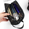 A black mesh storage bag is open, revealing several glass makeup bottles inside.