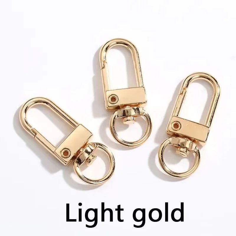 Ein Paar goldfarbener Metall-Swivel-Haken für Taschen und Gürtel.