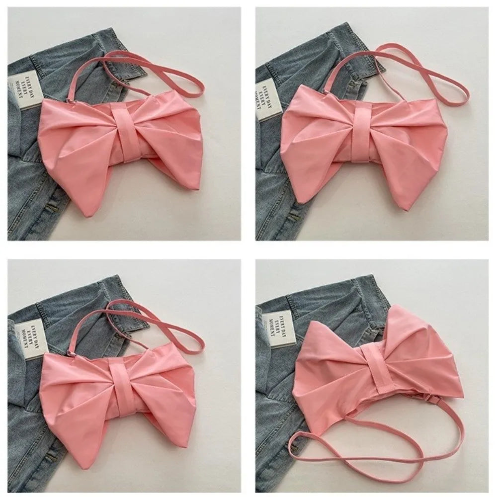 A pink pleated bow crossbody tote bag is shown against a denim background.
