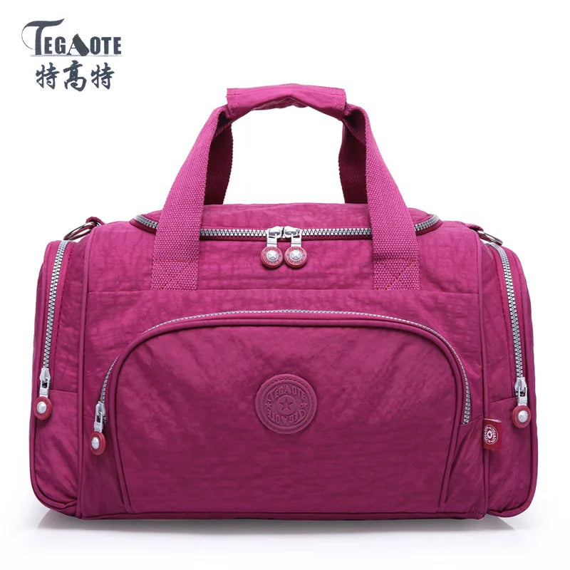 A magenta nylon travel duffle bag with zippered compartments and handles.