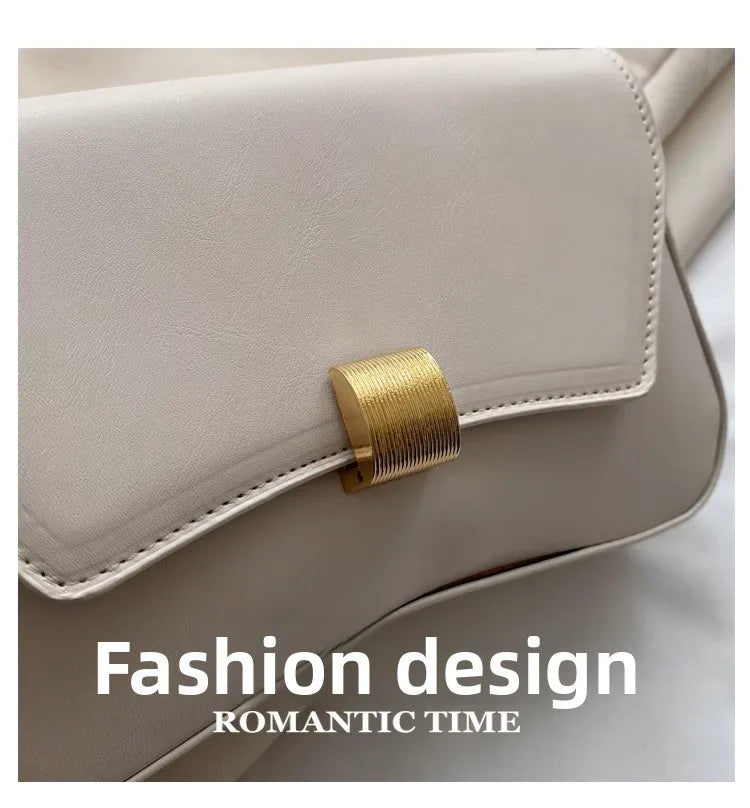A close-up of a light beige leather crossbody bag featuring gold hardware and a soft, elegant design.