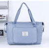A light blue expandable travel organizer bag with handles is shown next to a shelf.