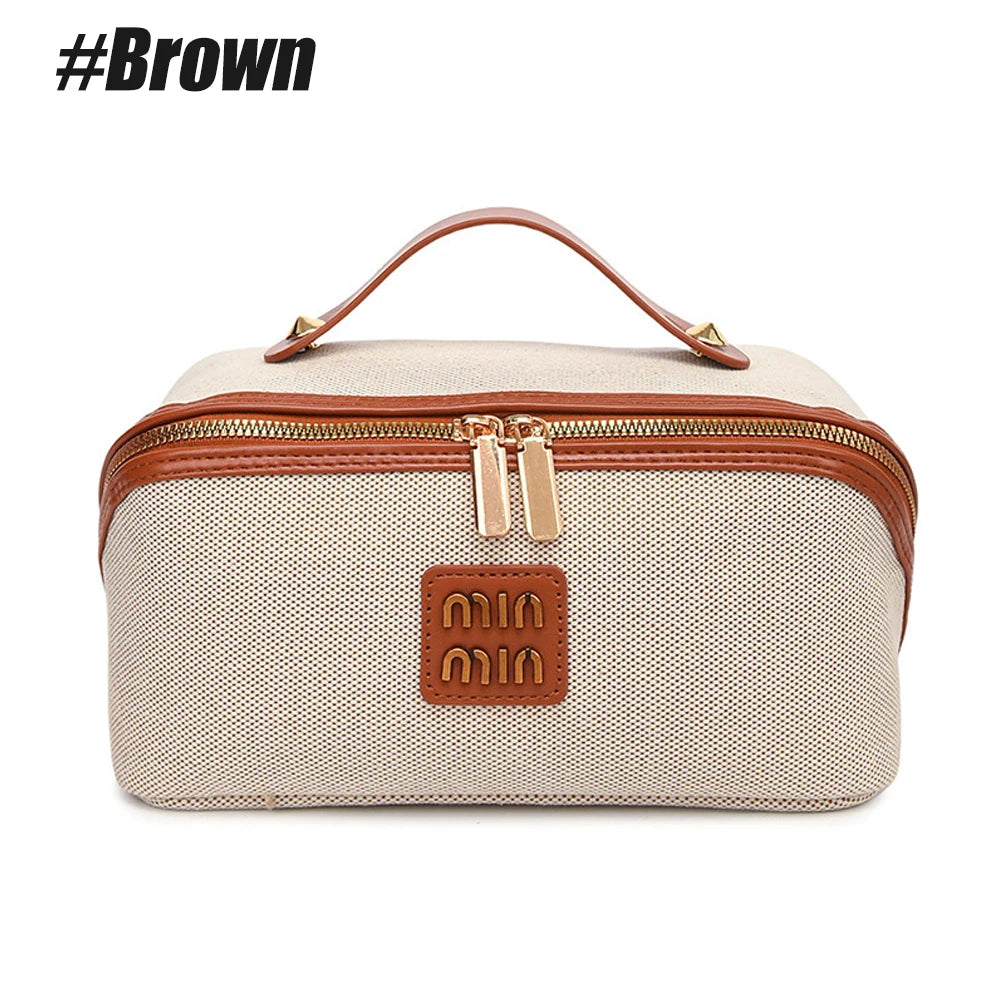 A beige and brown leather travel toiletry bag with a handle and zipper closure.