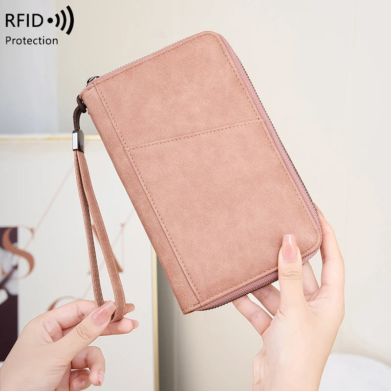 A light pink RFID blocking travel wallet is shown being held by a person.