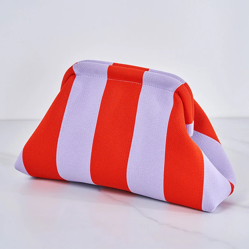 Pochette en crochet rayée orange et blanc posée sur une surface blanche.