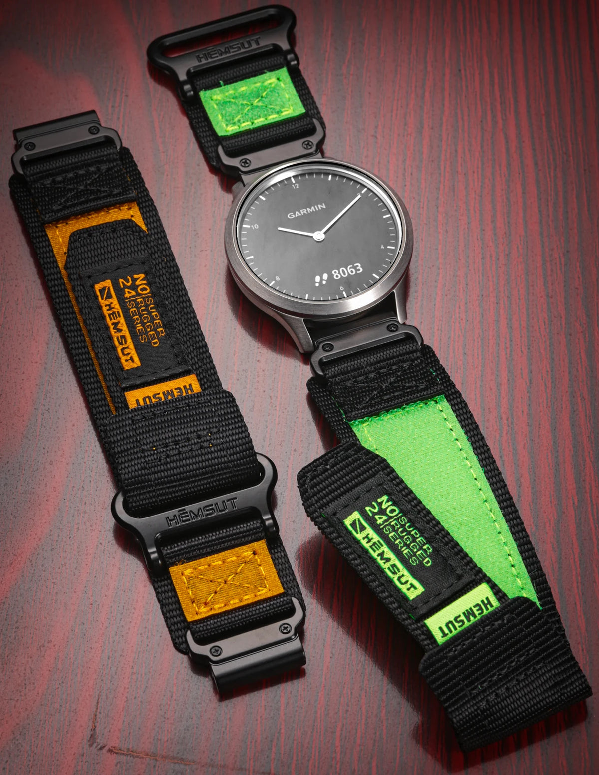 A black nylon sport strap with a green accent is shown alongside a Garmin watch.