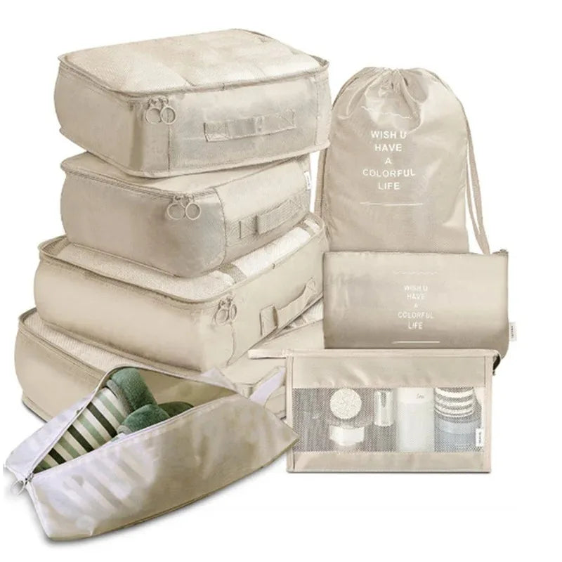 A set of beige mesh packing cubes and a drawstring bag for travel organization.