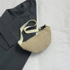 A beige corduroy crossbody waist bag with a light strap is shown next to a dark gray blazer.
