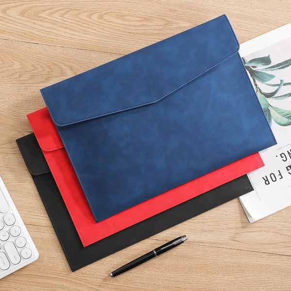 A navy blue premium PU leather A4 document organizer folder with a red and black pen on a wooden surface.