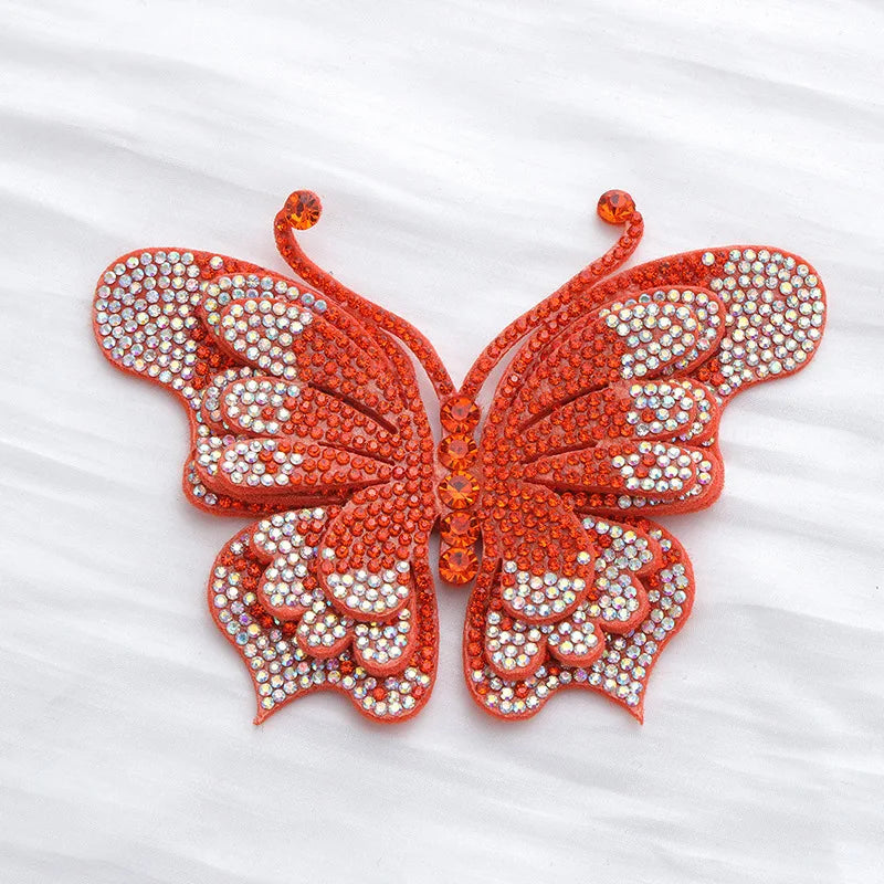 An orange rhinestone butterfly applique sticker with intricate wing details.