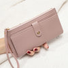 A mauve PU leather coin purse and card holder is held by a hand against a white textured background.