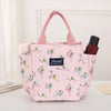 Una lonchera térmica rosa con estampado floral junto a una bolsa marrón oscura.