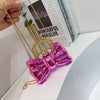 A glossy pink heart-shaped acrylic evening clutch with a gold chain strap displayed against a white background.