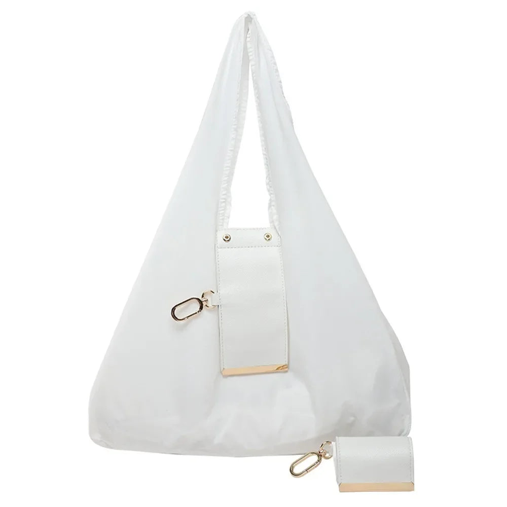 A white foldable mini keychain tote bag with gold accents shown from the front.