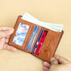 A hand holds an open brown leather bifold wallet containing several credit cards and cash.