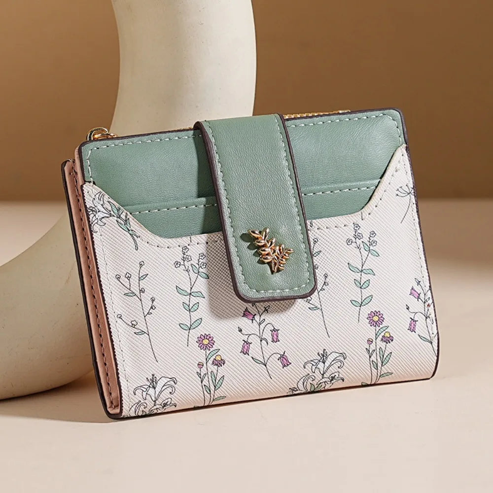A light mint green and white patterned slim card holder wallet with a leather strap.