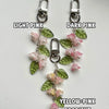 Handmade Lily of the Valley flower keychains in light pink, dark pink, and yellow-pink gradient colors.